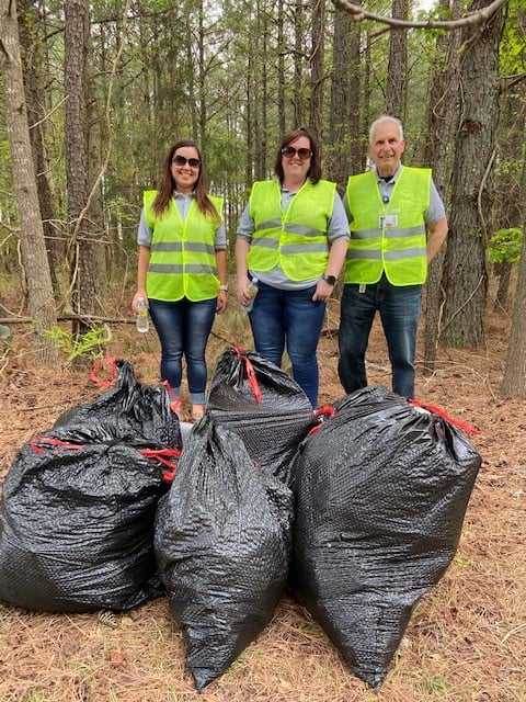 Three volunteers with trash bags